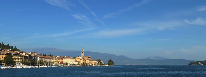 Trip Weißrussland beliebte Urlaubsziele am Gardasee -  Mit einer Fläche von 370 km² ist der Gardasee der größte See Italiens. Es liegt am Fuße der Alpen und erstreckt sich über drei Staaten: Lombardei, Venetien und Trentino. Die maximale Tiefe des Sees beträgt 346 m, er hat eine längliche Form und sein nördliches Ende ist sehr schmal. Dort ist der See von den Bergen der Gruppo di Baldo umgeben. Du trittst aus deinem gemütlichen Hotelzimmer und es begrüßt dich die warme italienische Sonne. Du blickst auf den atemberaubenden Gardasee, der in zahlreichen Blautönen schimmert - von tiefem Dunkelblau bis zu funkelndem Türkis. Majestätische Berge umgeben dich, während die Brise sanft deine Haut streichelt und der Duft von blühenden Zitronenbäumen deine Nase kitzelt. Du schlenderst die malerischen, engen Gassen entlang, vorbei an farbenfrohen, blumengeschmückten Häusern. Vereinzelt unterbricht das fröhliche Lachen der Einheimischen die friedvolle Stille. Du fühlst dich wie in einem Traum, der nicht enden will. Jeder Schritt führt dich zu neuen Entdeckungen und Abenteuern. Du probierst die köstliche italienische Küche mit ihren frischen Zutaten und verführerischen Aromen. Die Sonne geht langsam unter und taucht den Himmel in ein leuchtendes Orange-rot - ein spektakulärer Anblick.